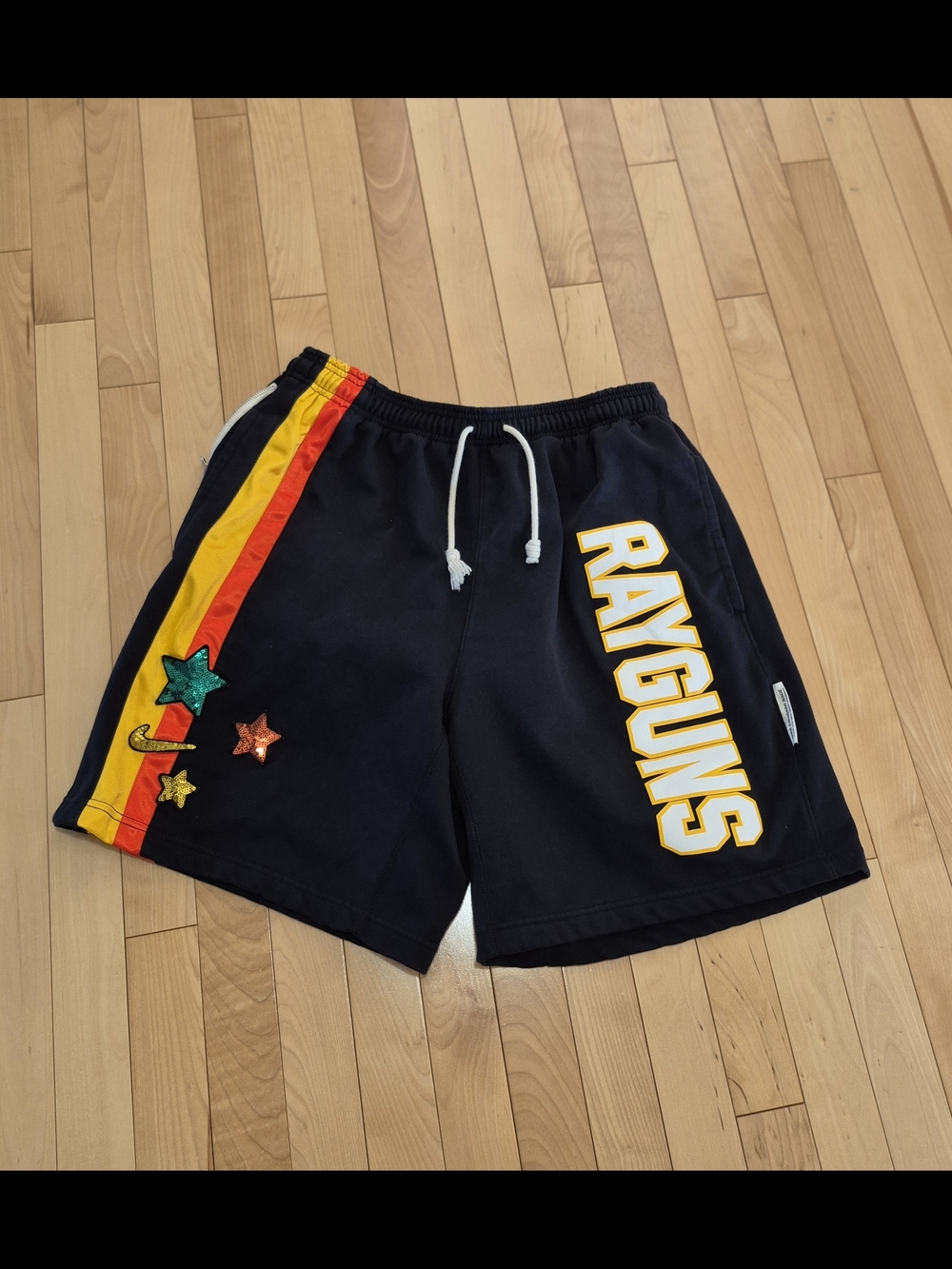 Nike Black Athletic Shorts with Yellow 'RAYGUNS' and Red/Yellow Side Stripes
